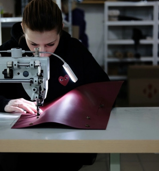 femme en train de coudre du cuir rouge